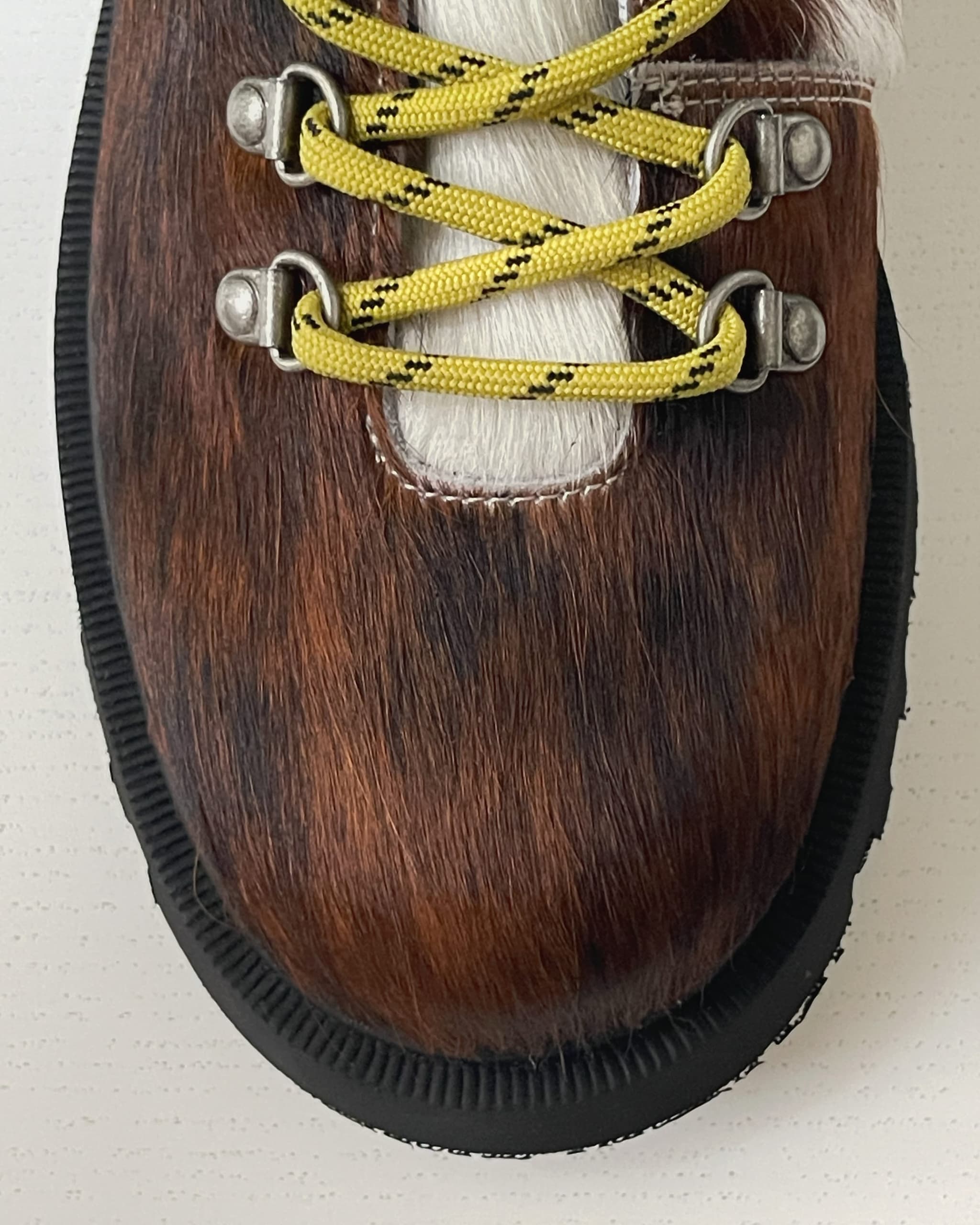 Close-up of a Kazar leather boot with bright yellow laces.