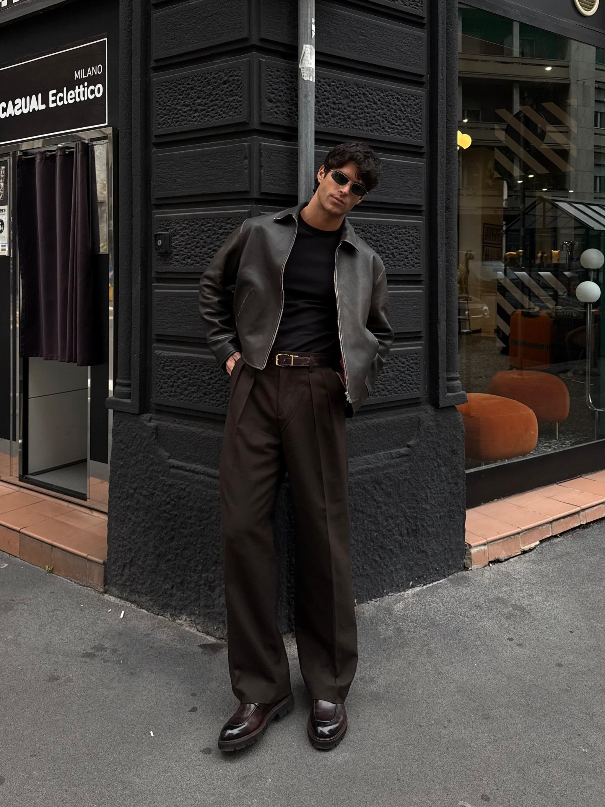 Man in a Kazar look standing outside a Milan storefront.