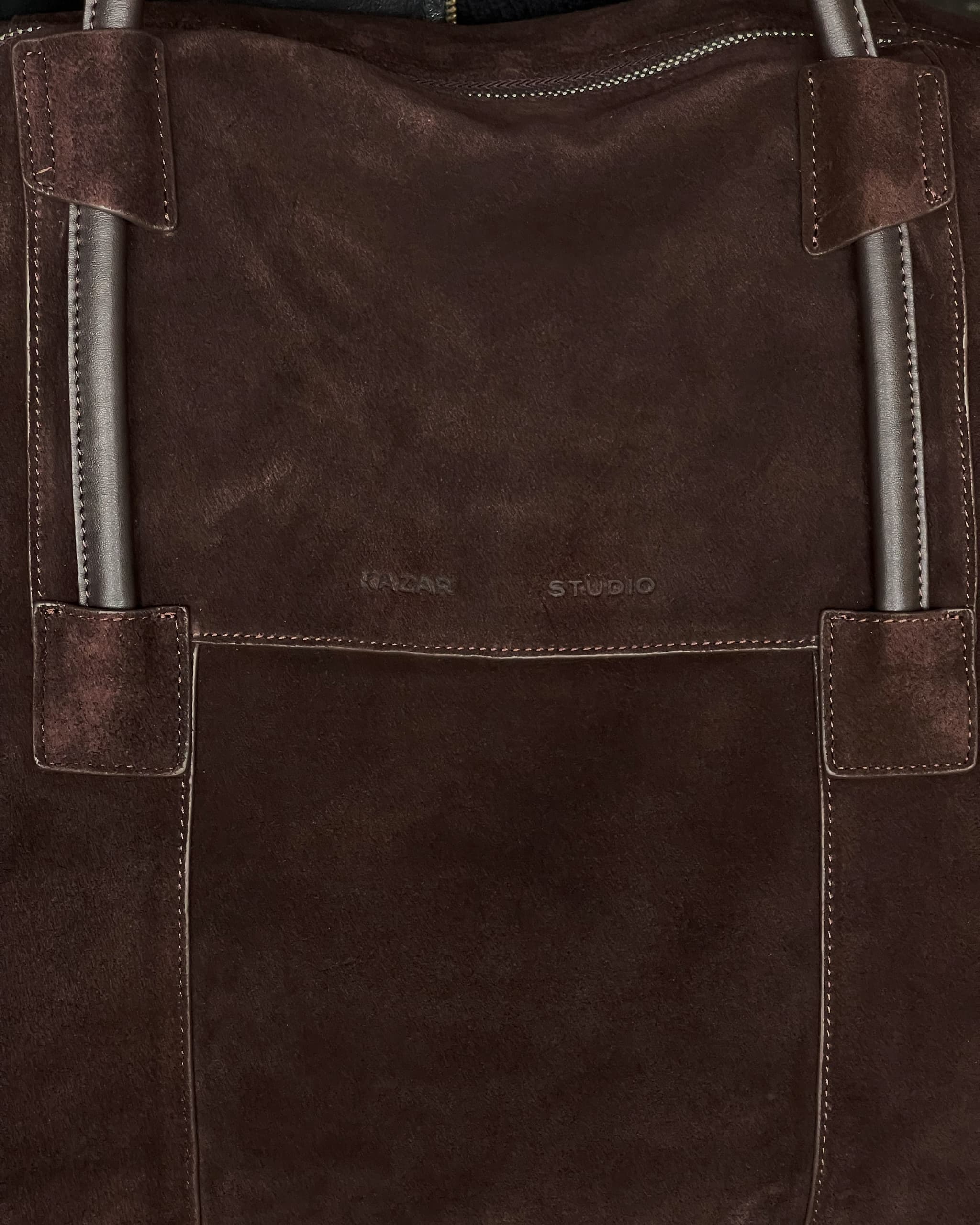 Brown suede Kazar tote bag photographed against a matching backdrop.